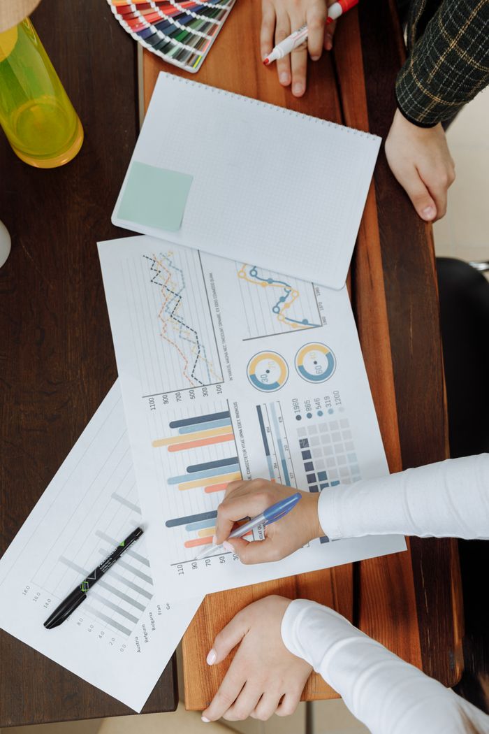 Pohled shora na obchodní tým, který při strategickém plánování analyzuje grafy a data na papíře.